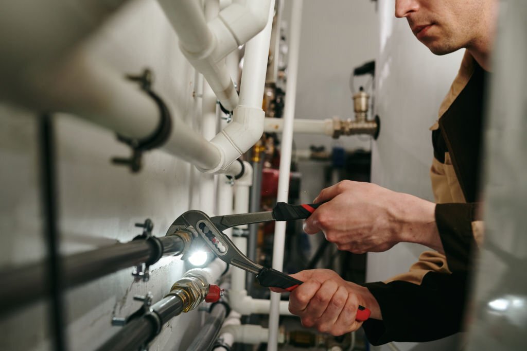 Repairman using a tool to fix parts of pipes during work Repairman using a tool to fix parts of pipes during work